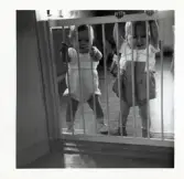 Fotografi på Mikael och Nicklas stående bakom en barngrind i Lilla Källbäck.