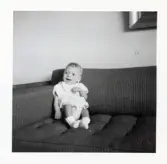 Fotografi på Jonas sittande i ett hörn av en soffa i Lilla Källbäck.