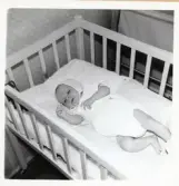 Fotografi på Leif som ligger i sin spjälsäng i Lilla Källbäck.