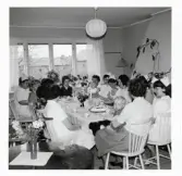 Fotografi på avtackning med kaffe för Gudrun som skulle sluta, Maria sitter i knä.