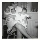 Fotografi på en barnsköterska med tre småttingar i sitt knä på Lilla Källbäck.