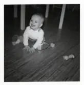 Fotografi på en gosse som sitter på golvet och leker med leksaker i Lilla Källbäck.