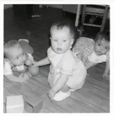 Fotografi på Reino, Carina och ? som leker på golvet i Lilla Källbäck.