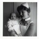 Fotografi på barnsköterska Kristina med barn i famnen på Lilla Källbäck.