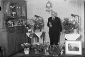 August  Johansson med blommor och presenter i hemmet, Väsby, Alunda, Uppland 1945