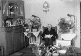 August Johansson med blommor och presenter i hemmet, Väsby, Alunda, Uppland 1945