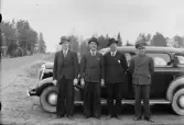Chaufför med tre män vid bil, Timrå, Medelpad