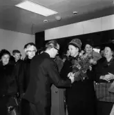 Direktör Paul Holmer ger en bukett blommor till en av kunderna vid öppning av det nya varuhuset Rosen den 8 april år 1965.