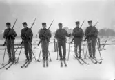 Foto av en grupp meniga i vinteruniform, på skidor.
