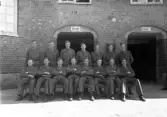 Foto av en grupp meniga i uniform, utanför en kasern på I 11, Växjö.