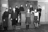 Foto av en mindre skolklass med sin lärare i ett klassrum.
Fortsättningsskola (?).