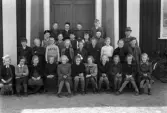 Foto av en skolklass med lärare, som samlats utanför skolan.
