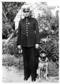 Överkonstapel Manfred Lundin med hund i en trädgård någonstans i Växjö, 1941.
