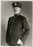 Poliskonstapel Arvid Petrusson, Växjö, ca 1935.
Knäbild, halvprofil. Ateljéfoto.