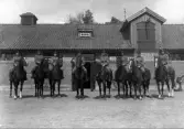 Åtta man till häst framför ett stall. 
I 11, Växjö