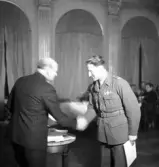 Sammanträde på Stadshotellet, 1943. 
Överlämnande av diplom till en medelålders herre i uniform.