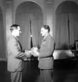 Sammanträde på Stadshotellet, 1943. 
Överlämnande av något (en medalj ?) till en herre i uniform.