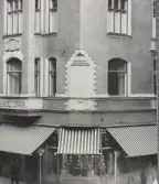 Markiser över skyltfönster i hörnhuset Storgatan och Fredsgatan, 1970-tal