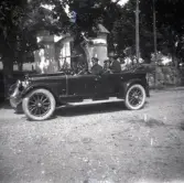 Erik Stensiö sitter i baksätet i en bil med tre kvinnor. Från höger är Ketty Andersson, Tilia Andersson och troligen Emma Johansson. Bilen står framför en kyrkogård.