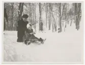 Vinter i Stockholm. Lotte Laserstein åker pulka med ett barn.