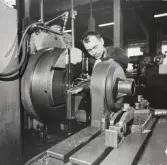 Man jobbar vid maskin på AB Avos, 1950-tal