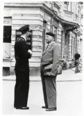 Poliskonstapel Lennart Baugert pratar med Sture Ivarsson i hörnet Kungsgatan - Sandgärdsgatan, 1951.