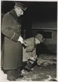 Poliskonstaplarna Eric Hasselgren och Olof Ringius undersöker något intressant under uppdrag, 1957.
Trol. reportagebild.