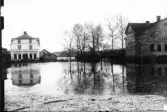 Översvämning i Bollnäs köping 1916. Till vänster Sandberg & Styfs Järnhandel, till höger gamla tingshuset (som senare en tid blev Folkets Hus) och i mitten bron över 