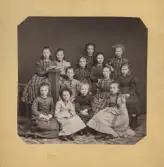 Porträtt av en skolklass med flickor. 
Text baksida kort: Svedlund. Klass 2 våren 1874. Några otydliga namninitialer samt Lydia H. och Tea Lindgren?