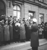 När våren kom, 1944. 
En manskör sjunger på trappan till Stadshotellet.