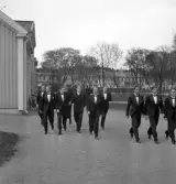 De första studenterna. 1944.
En klass studenter, uppsträckta i smoking, på väg från Domprostgården
till Växjö Högre Allmänna Läroverk.