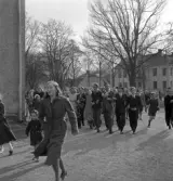 De första studenterna. 1944.
Studenter och anhöriga m.fl. på väg mot Tegnérstatyn vid domkyrkan. 
I bakgrunden ser man några av husen vid Linnégatan.