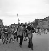 De första studenterna. 1944.
En student bärs iväg längs Stortorget. Till höger syns Stadshotellet och i bakgrunden skymtar husen längs Kronobergsgatan m.m.