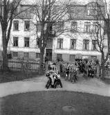 De första studenterna. 1944.
Några studenter bärs in på gårdsplanen till skolhemmet på Västergatan.