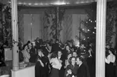 Dans på Järnvägshotellet. Par dansar runt i den så kallade Rotundan, en julgran syns till vänster. 