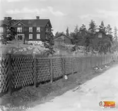 Mosebacke till vänster och husgaveln till höger är Gråbo. Grusvägen är Nygatan i Ljusne.