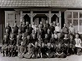 Skolfoto, skolklass framför skolhuset. I mitten lärare Olof Wahlby.