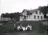 Familjen Svensson, föräldrapar med fem barn, fotograferade i grässluttningen framför gården. Vandered, Drängsereds socken. Namn: Georg Svensson, Filip Svensson, Sigfrid Svensson, Elsa Svensson, Flora Svensson, Augusta Svensson, Sally Svensson.