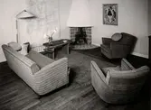 Vardagsrum. Två fåtöljer, en soffa samt en öppen spis i ena hörnet. Nordiska Kompaniet. Arkitekt A. E. Hjort, utställningen ”Vackra möbler” i maj 1937.