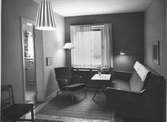 Interiör från ett rum på Hotell Malmen i Stockholm. Inredningen med soffa, bord, fåtölj, lampa och textilier kommer från  varuhuset Nordiska Kompaniet.