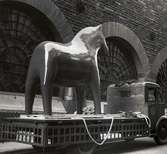 Stor dalahäst (tillverkad för världsutställningen i New York 1939) uppställd på lastbilsflak. Nordiska Kompaniet.