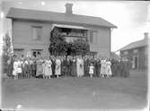Gruppfoto framför hus med brudparet i mitten, tidigt 1900-tal. Lima, Dalarna