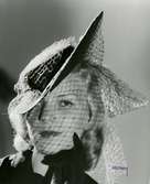 Porträtt av kvinna i hatt med ljust flor från Rose Descat.