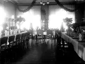 Restaurang. Rummet är smyckat med blommor. Långbord med blommor och krokan. Var kan detta vara?