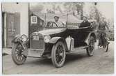 Postkort - AB Eric Lindvalls representant Artur Ax i baksätet på firmabilen, Uppland, omkring 1915