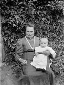 Sannolikt Josef Ärnströms svägerska Maja med ett barn, Hållnäs socken, Uppland