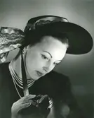 Porträtt av kvinna med hatt i svart filt och mönstrat hattband i turkos. Uppvisning mars 1947. Hattar använda vid franska avdelningen.