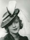 Fb, Porträtt av kvinna med hatt från Caroline Reboux. Marinblå med ripsband och flor.