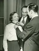 En kvinna får en slips på sig.