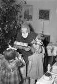 Tomte delar ut paket till tre barn, Uddevalla 1949